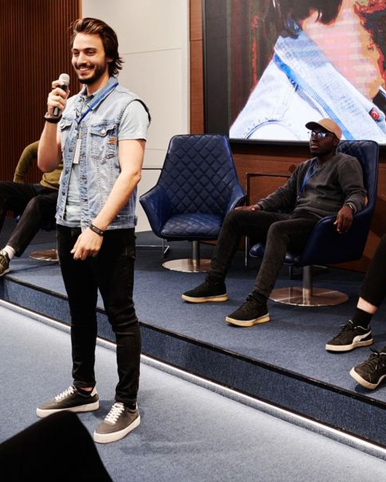 Un animateur au micro devant un public lors d'un événement d'entreprise.
